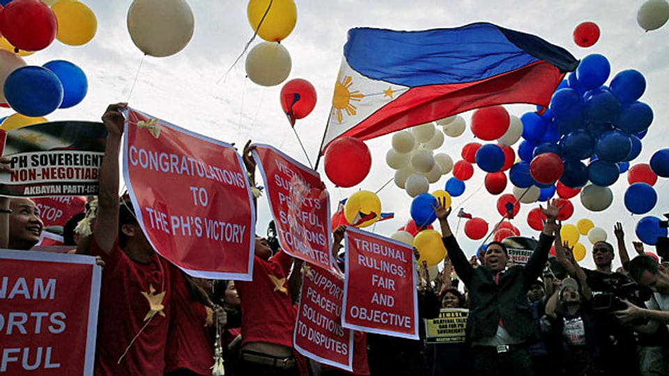 Eins zu null für die Philippinen. Das Haager Schiedsgericht sieht Chinas Ansprüche im südchinesischen Meer als ungerechtfertigt. Bild: Aktivisten von den Philippinen feiern in Manila mit bunten Ballonen den Schiedsspruch aus Den Haag.