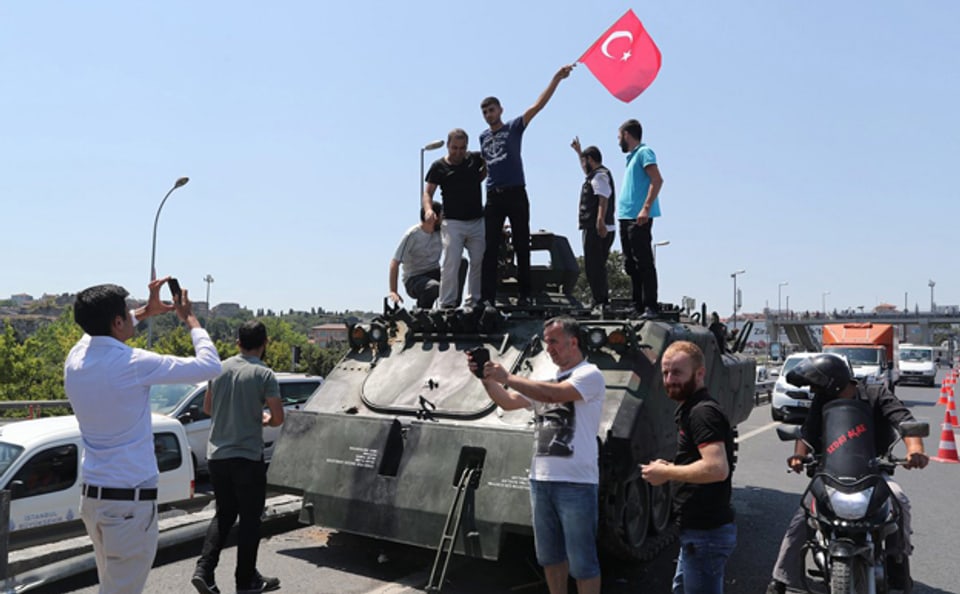 türkische Bürger schwenken eine Landesfahne auf einem Panzer der türkischen Armee
