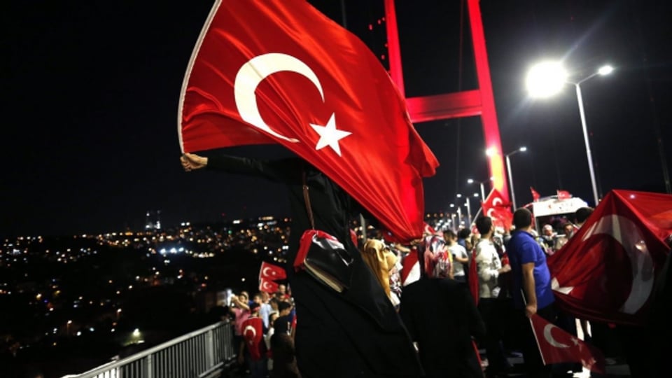 Anhänger des türkischen Präsidenten Erdogan halten türkische Fahnen auf der Bosporus-Brücke während einer Demonstration gegen den gescheiterten Putsch.