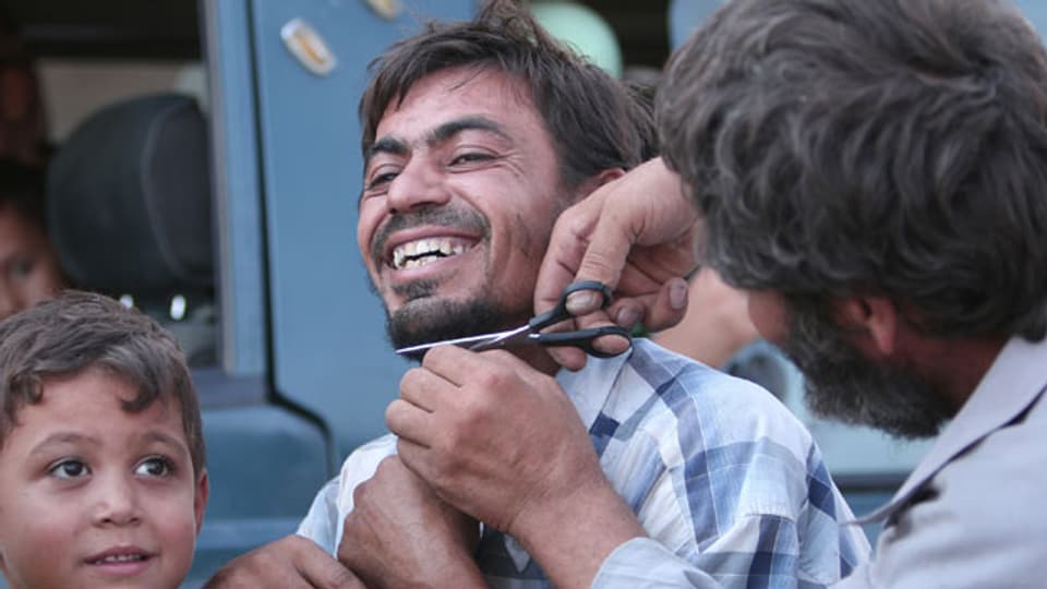 Ein Mann lässt sich nach der Befreiung in Manbidisch den Bart schneiden.