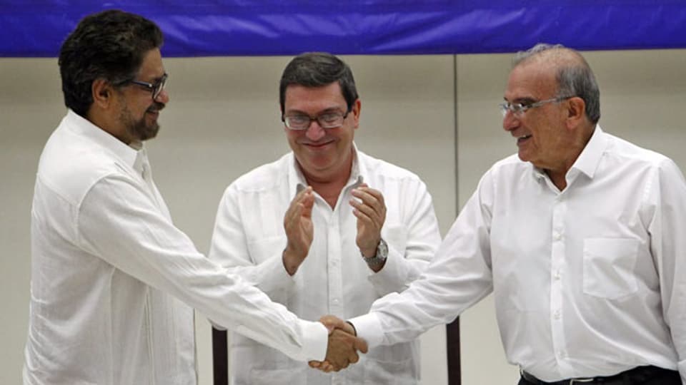 Der Delegationschef der Farc, Iván Márquez (links), reicht dem Verhandlungsführer der Regierung, Humberto de la Calle, die Hand. In der Mitte, Kubas Aussenminister Bruno Rodriquez.
