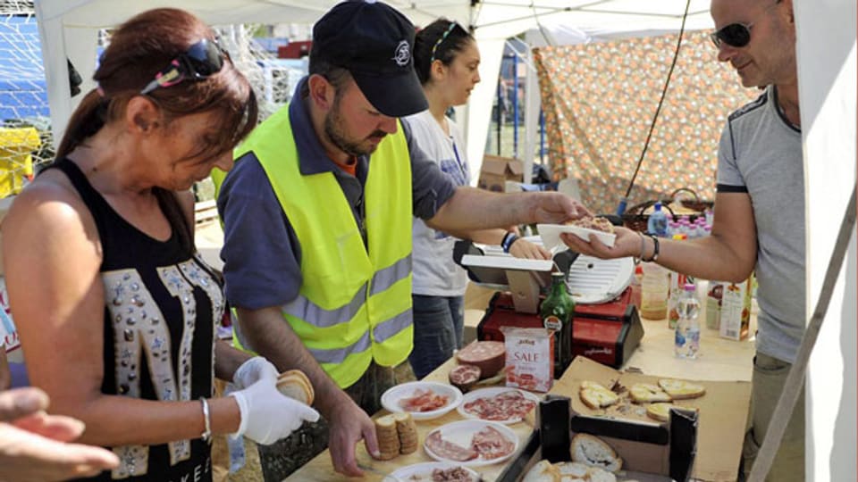 Freiwillige Helferinnen und Helfer verteilen Nahrungsmittel an Menschen, die beim schweren Erdbeben in Mittelitalien zu Schaden kamen.