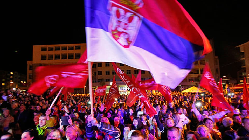 Eine bosnische Flagge weht über der Menschenmenge, die der Rede von Milorad Dodik in Pale zuhört.