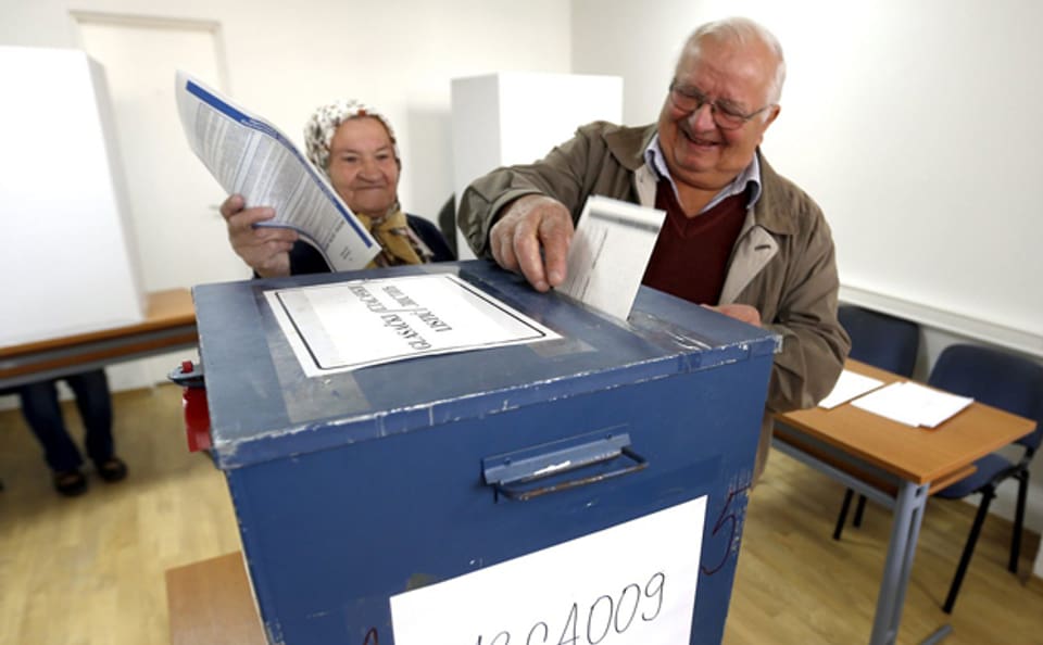 Ein älteres bosnisches Ehepaar gibt ihre Stimmen ab in einem Wahllokal in Sarajewo.