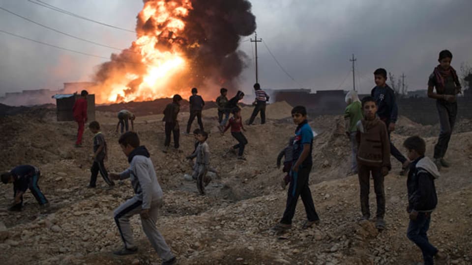 Kinder in der Nähe eines brennenden Ölfelds südlich von Mosul, Irak.