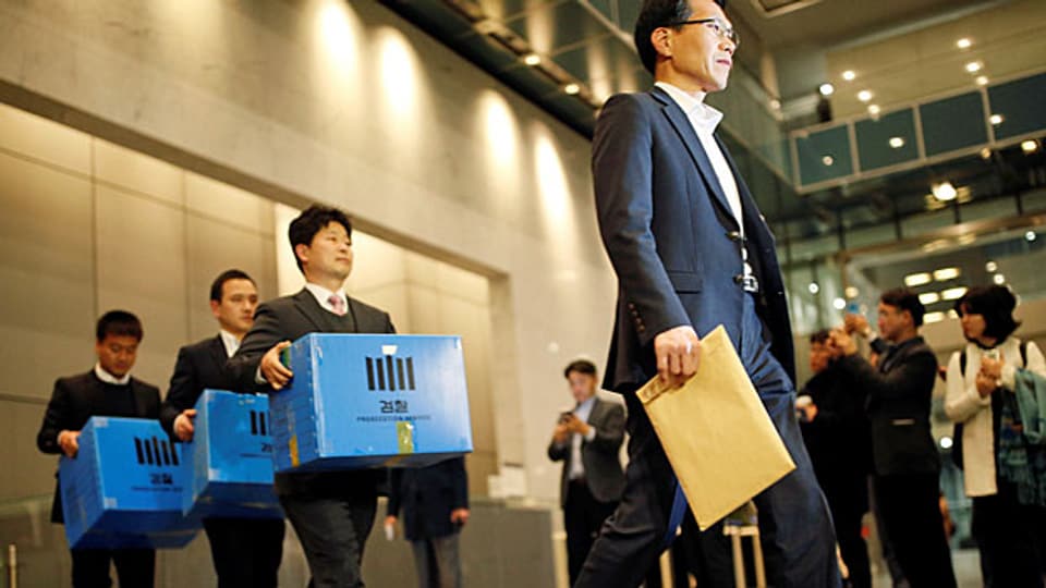 Der Korruptionsskandal um die südkoreanische Präsidentin wirft Wellen: Mitglieder der Staatsanwaltschaft tragen Kisten mit beschlagnahmtem Material aus dem Samsung-Geschäftssitz in Seoul.