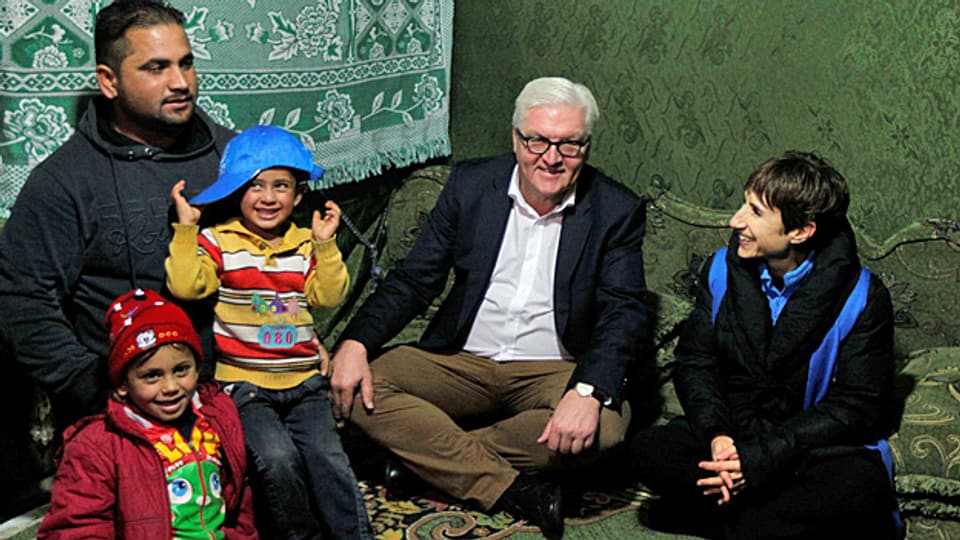 Der deutsche Aussenminister Frank-Walter Steinmeier sitzt mit einer Familie in einem Flüchtlingslager im libanesischen Bekaa-Tal.