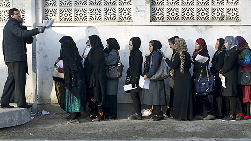 Afghanische Frauen stehen vor einem Gebäude in Kabul Schlange, um einen Pass zu beantragen.