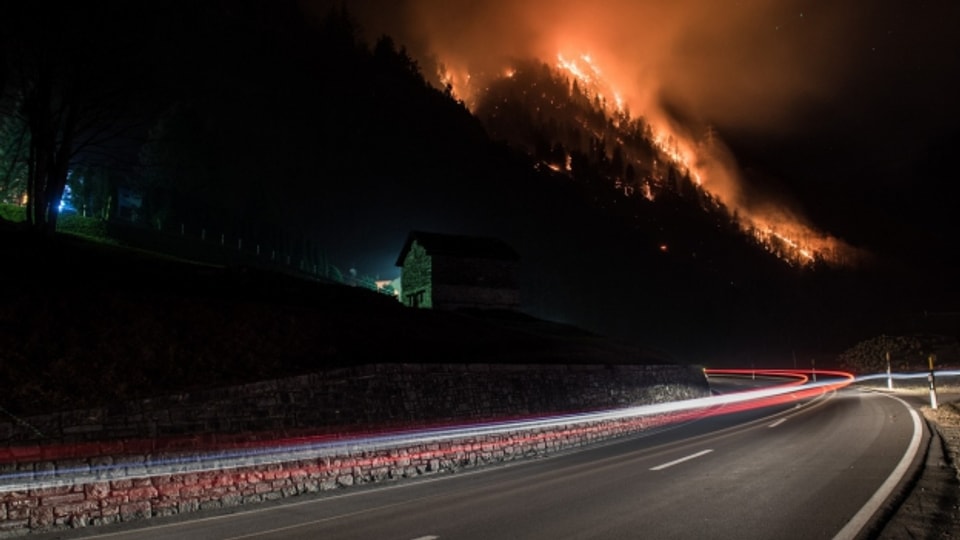 Der Wald brennt über der Autobahn A13 im Misox, Graubünden.