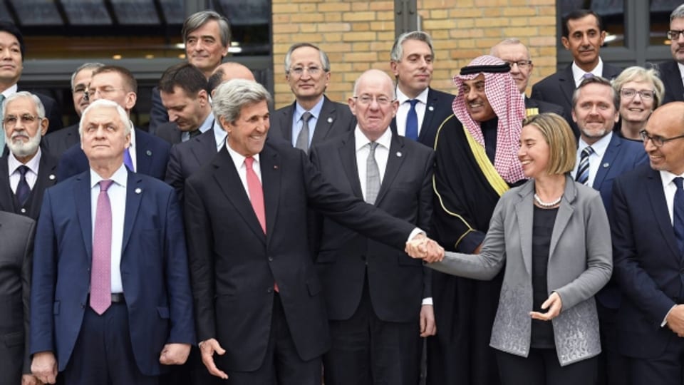 US-Aussenminister John Kerry drückt die Hand von EU-Aussenministerin Federica Mogherini beim Gruppenfoto der an der Pariser Nahostkonferenz teilnehmenden Repräsentanten