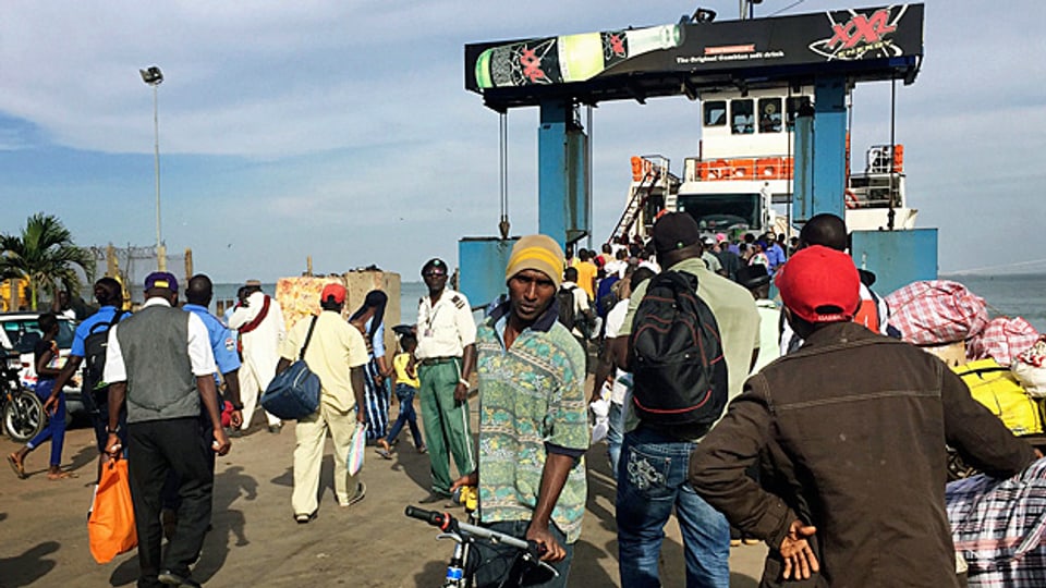 Nicht nur Touristen und Touristinnen verlassen die gambische Hauptstadt Banjul; auch Gambier versuchen, die Fähre zu erreichen, die sie ausser Land bringen soll.