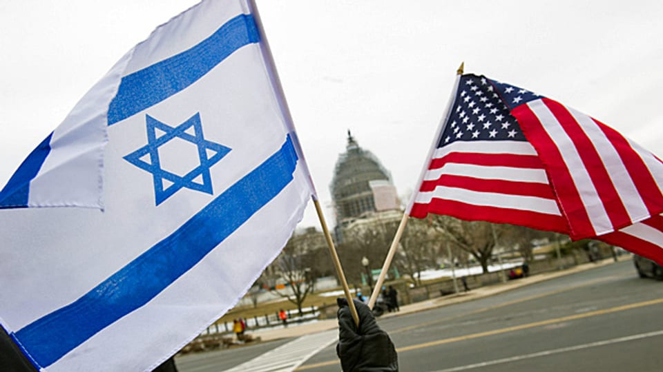 Ein pro-israelische Demonstrant schwenkt je eine Flagge Israels und der USA vor dem Capitol in Washington.