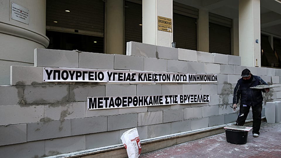 «Wir sind nach Brüssel transferiert worden» steht an einer Mauer des griechischen Gesundheitsministeriums. Es sei höchstwahrscheinlich, dass die Regierung trotz gegenteiliger Versprechen weiteren Kürzungen im Gesundheitssystem zustimmen werde, sagt der Gewerkschafter im Beitrag.