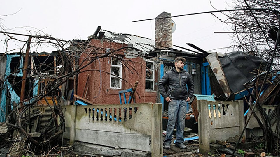 Immer mehr Menschen in der Ostukraine fühlen sich von der Regierung in Kiew im Stich gelassen. Bild: Ein Mann in einem ostukrainischen Dorf steht vor seinem zerstörten Haus.