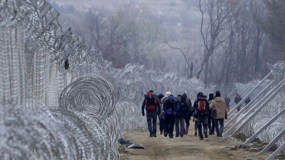 Flüchtlinge zwischen den beiden Grenzzäunen an der griechisch-mazedonischen Grenze.
