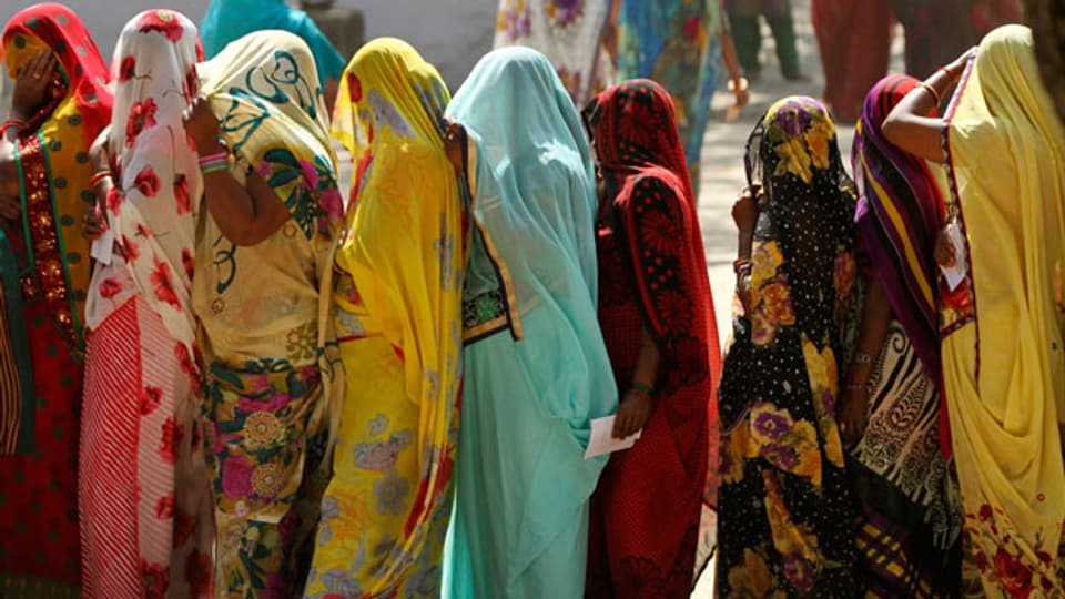 Frauen stehen Schlange vor einem Abstimmungslokal in Allahabad, Uttar Pradesh.