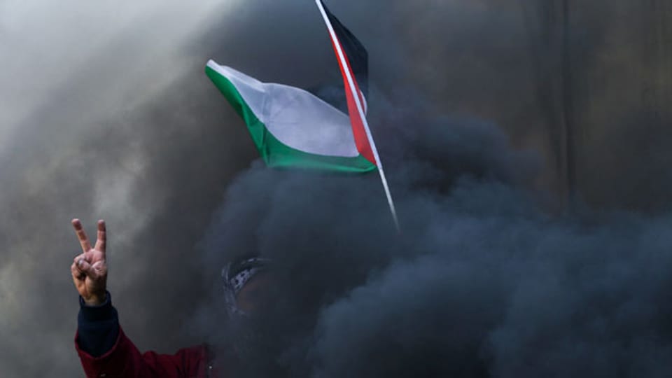 Ein Demonstrant mit einer palästinensischen Fahne bei Zusammenstössen mit israelischen Truppen am 17. Februar 2017 bei Ramallah.