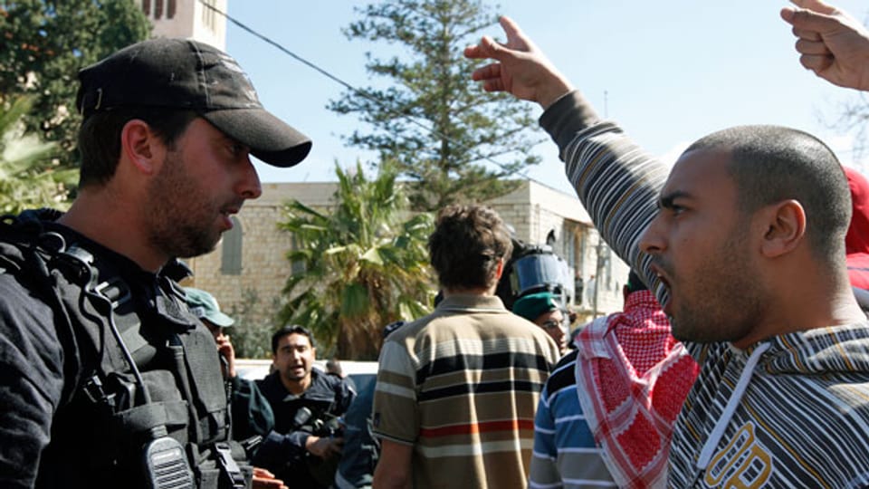 Ein israelischer Araber in Jaffa gestikuliert vor einem israelischen Polizisten.