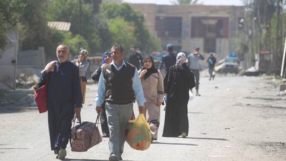 Vertriebene Iraker fliehen mit ihren Habseligkeiten aus ihren Häusern in Mossul.