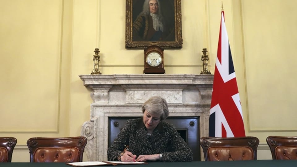 Unter den Augen der Fotografen - Theresa May setzt die Unterschrift unter das Brexit-Papier.