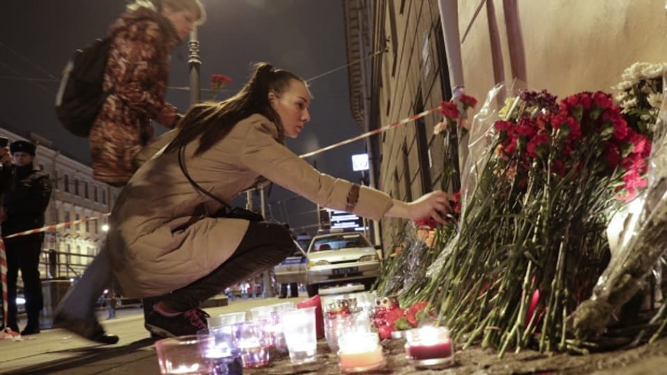 Menschen legen Blumen nieder für die Opfer der Bombenexplosion.