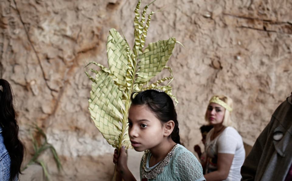 Der Palmsonntag wurde für ägyptische Kopten zum Trauertag. Ein christliches Mädchen trägt einen symbolischen Palmzweig bei einer Feier in Kairo.