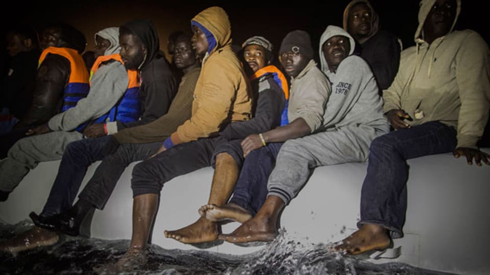 Afrikanische Flüchtlinge versuchen, auf einem überfüllten Schlauchboot nach Libyen zu gelangen.