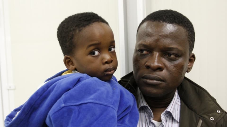 Hoffen auf Asyl: Ein afrikanischer Vater mit seinem Sohn bei der Ankunft in Italien.