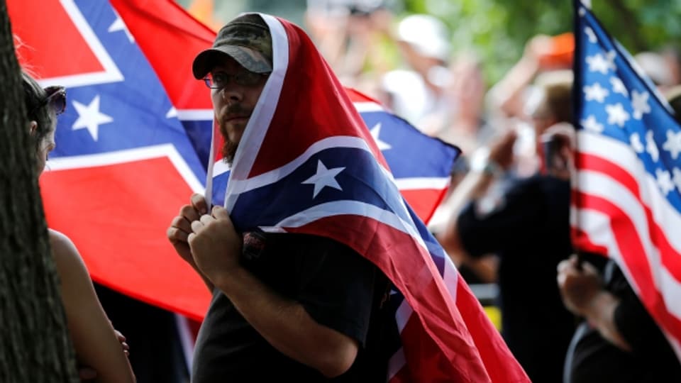 Ein Mitglied des Ku Klux Klans mit der Flagge der US-Südstaaten.
