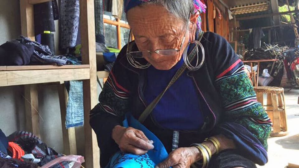 Die Frauen und Mädchen sind Angehörige des Stammes der Black Hmong, die den Touristen Batikkurse anbieten.
