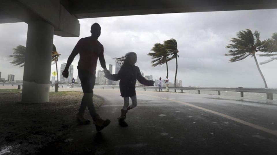 Der Wirbelsturm Irma hat sich abgeschwächt, aber die Gefahr für Florida ist noch nicht vorbei. Auf diesem Bild überqueren am Wochenende zwei Menschen in Miami die Strasse.
