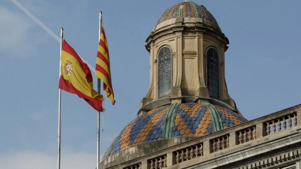 Die spanische und die katalanische Flaggen wehen auf dem Regierungsgebäude in Barcelona.