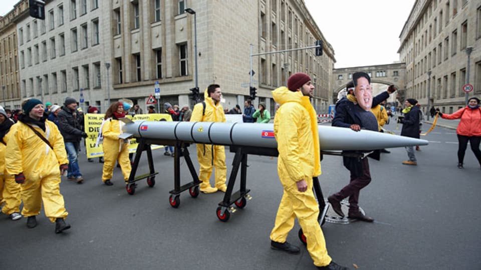 Mit einer Menschenkette zwischen den Botschaften der USA und Nordkorea demonstrieren in Berlin Menschen gegen atomare Aufrüstung.