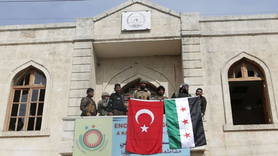 Mitglieder der türkischen Armee und der Freien syrischen Armee hissen ihre Flaggen in Afrin, Syrien.