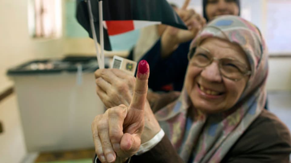 Magdah Ahmed, 78, zeigt ihren mit Tinte markierten Finger, nachdem sie am ersten Tag der Präsidentschaftswahl in einem Wahllokal in Kairo ihre Stimme abgegeben hat.