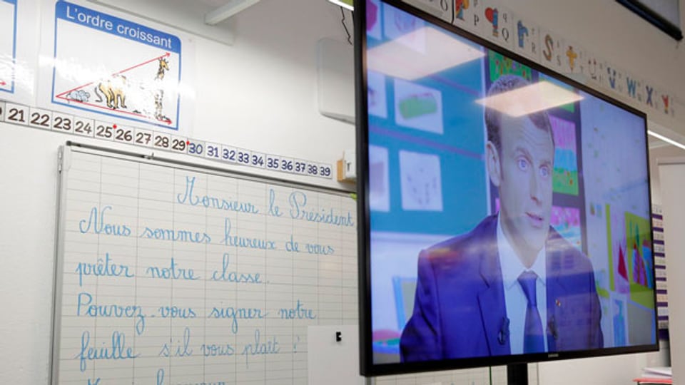 Der französische Präsident Emmanuel Macron erscheint im Fernsehen während des Interviews mit dem französischen Journalisten Jean-Pierre Pernaut im französischen Fernsehsender TF1 am 12. April 2018 in der Schule in Berdhuis westlich von Paris.