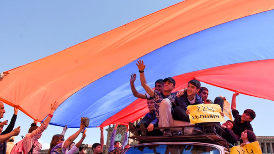 Demonstranten halten die Armenien-Fahne in die Höhe.