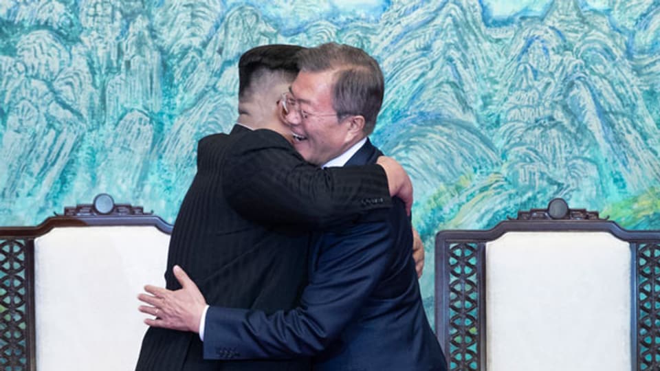 Der nordkoreanische Führer Kim Jong Un und der südkoreanische Präsident Moon Jae-in umarmen sich.