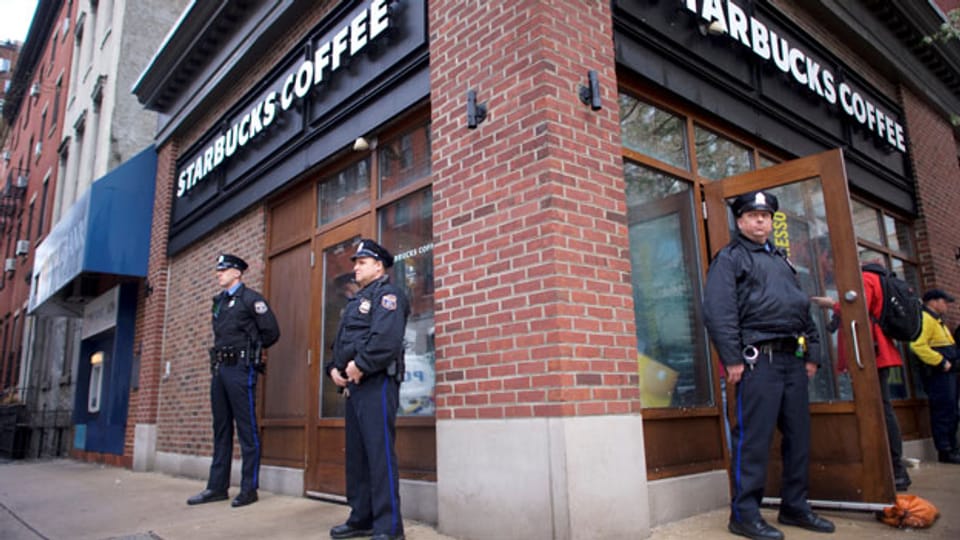 Polizeibeamte überwachen Demonstranten vor dem Starbucks, wo zwei schwarze Männer verhaftet wurden.