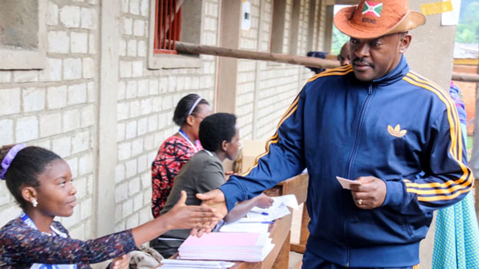 Der Präsident von Burundi, Pierre Nkurunziza, wird von einer Wahlbeamtin registriert.
