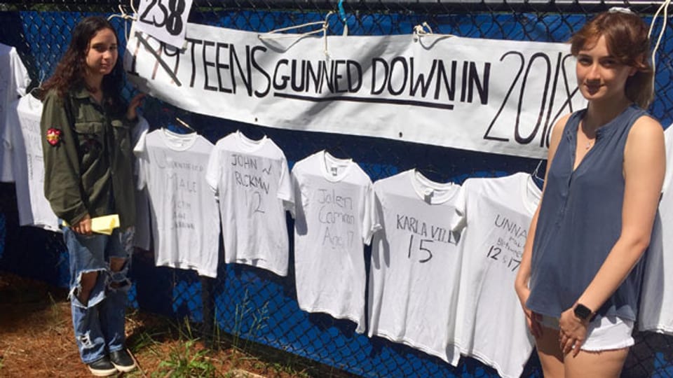 Dani Miller, 17, und Karenna Nambiar, 17, Schülerinnen der Winston Churchill High School in Potomac, MD. Sie stehen vor T-Shirts mit den Namen der 258 in den ersten 5 Monaten in den USA erschossenen Teenager.