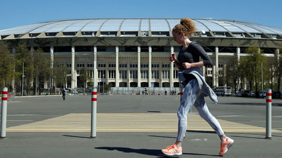 Eine Frau joggt vor dem Luzhniki Stadium in Moskau.