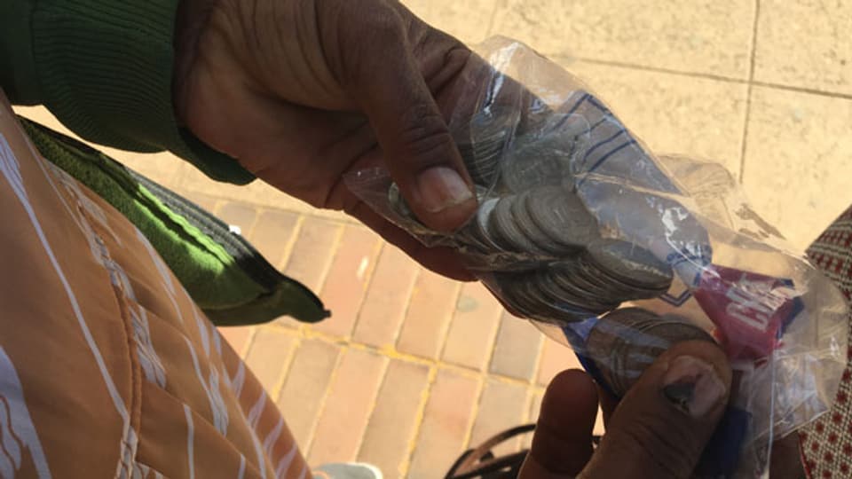 Drei Stunden anstehen für 20 Dollar Bargeld pro Tag, in 50 Cents Münzen, abgepackt in kleine Plastiksäcke.