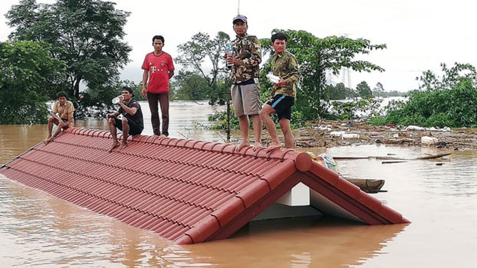 Dorfbewohner sind auf einem Dach eines Hauses gestrandet, nachdem der Xe Pian Xe Nam Noy Damm in einem Dorf Laos am 24. Juli 2018 zusammengebrochen ist.