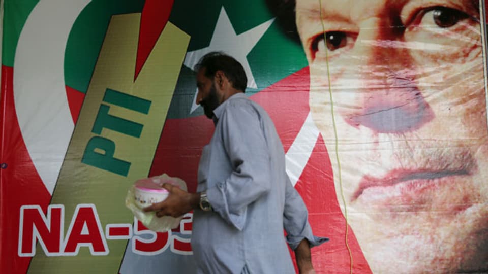 Wahlplakat mit Imran Khan, ehemaliger Cricket-Spieler, auf einem Markt in Islamabad, Pakistan.