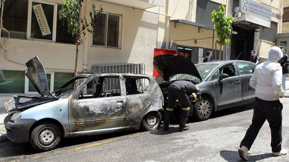 Vor einer Polizeiwache im Athener Stadtteil Exarcheia wurden im Mai 2011 mehrere Autos in Brand gesteckt. Was ist ihnen von den Protesten damals hängengeblieben?