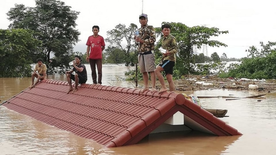 Nach dem Dammbruch suchten viele Menschen Schutz auf Hausdächern.