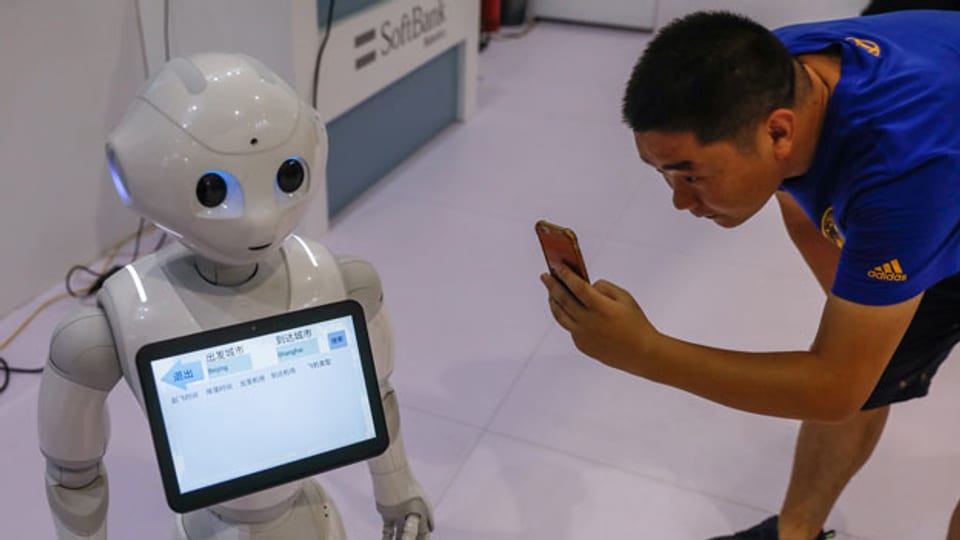 Ein Besucher fotografiert einen Roboter während der World Robot Konferenz 2018 in Peking, China, am 15. August 2018.