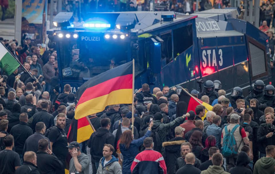 Rechte Demonstranten umringen einen Wasserwerfer