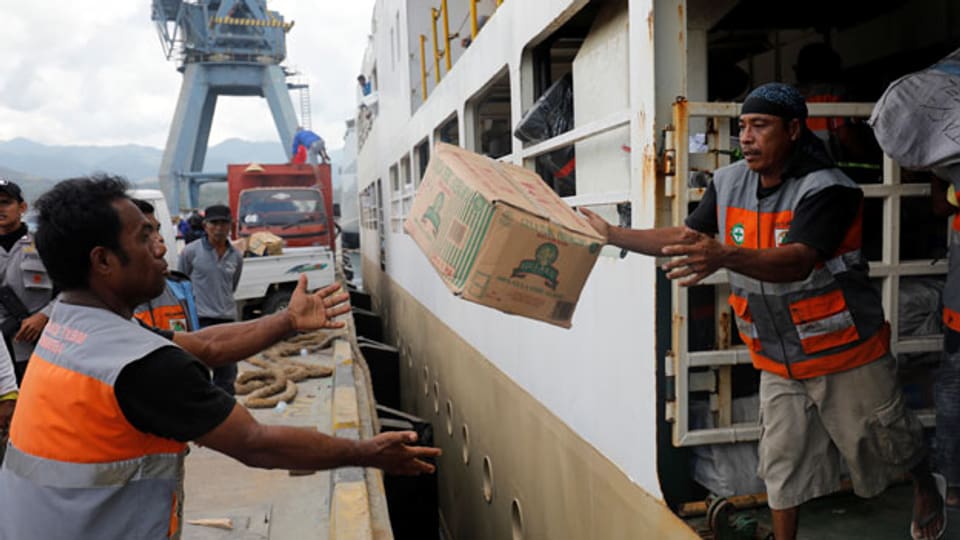 Hilfspakete für Erdbeben- und Tusnami-Opfer werden von einem Schiff in Palu entladen.